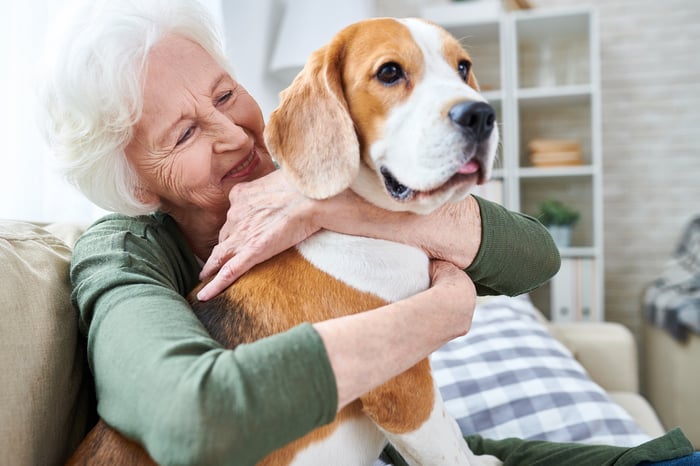 Smiling person hugging dog.