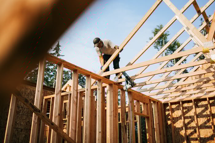 Worker putting up a house frame.