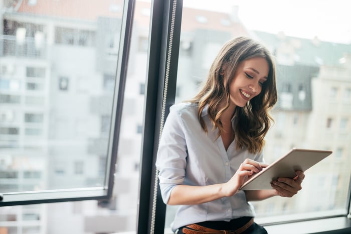 An investor in an office in a city looks at something on a tablet.