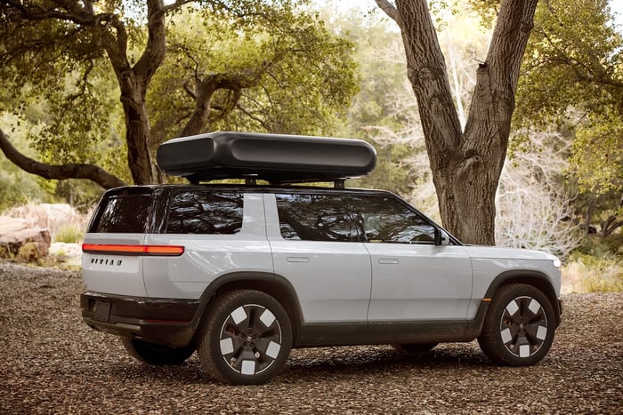 A white SUV in the woods.