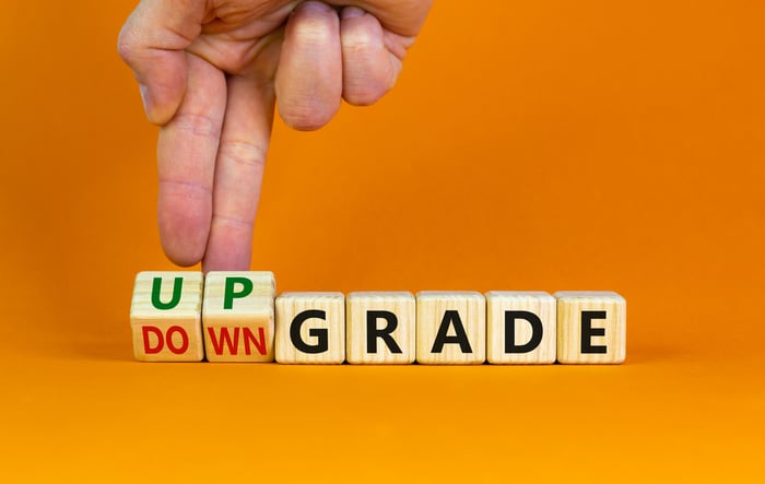 A hand flips blocks that spell Downgrade.