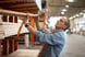 A person taking a beam of dimensional lumber off a shelf at a Home Depot home improvement store.