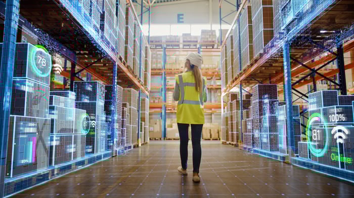 A person stands in the middle of a warehouse that appears to be fully automated.