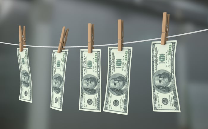 Dollar bills hanging on a clothes line.
