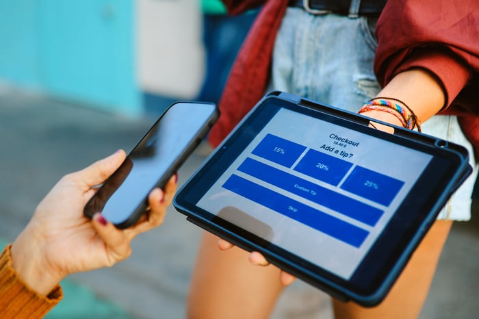 Person paying for a transaction with a smartphone.
