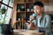 Person sitting drinking coffee with a mobile phone