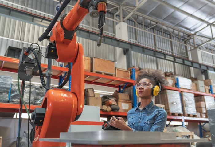Warehouse automation arm with warehouse technician. 