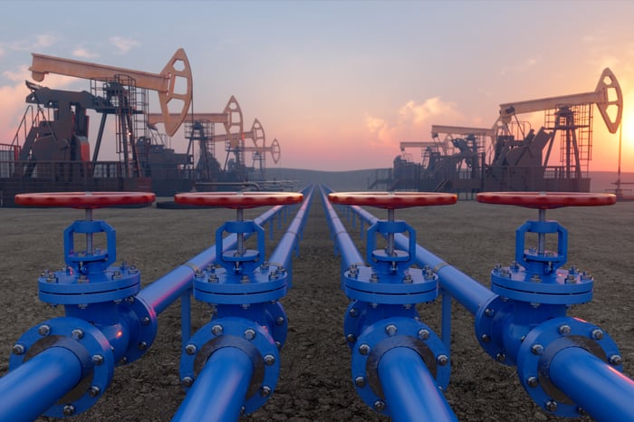 Blue pipelines leading to oil pumpjacks.