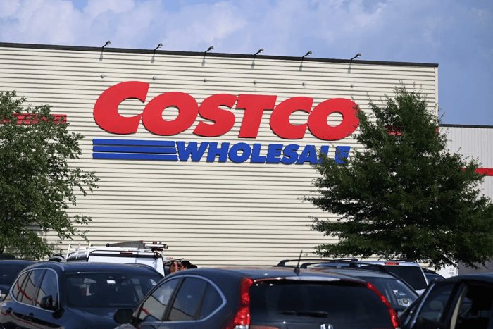Costco warehouse with parked cars in the foreground.