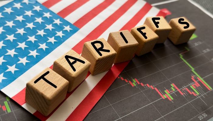 The word tariffs on top of a flag.