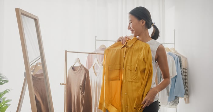 A person trying on clothing in front of a mirror.