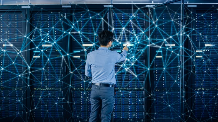 A person in a data center looks at a series of interconnected points.
