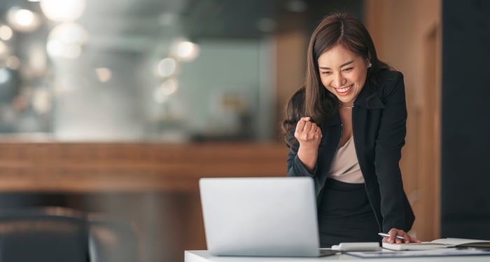 Person looking at a computer and cheering.