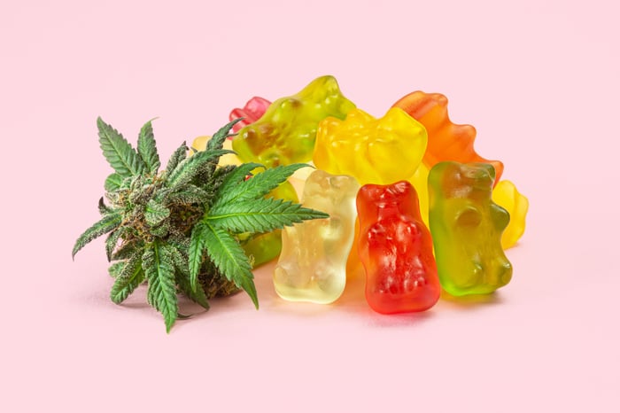 Marijuana flower next to a pile of edible gummy bears.
