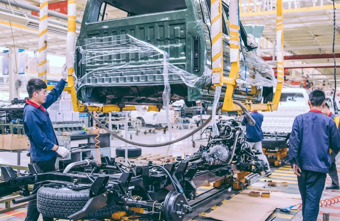 Workers on an EV manufacturing line.