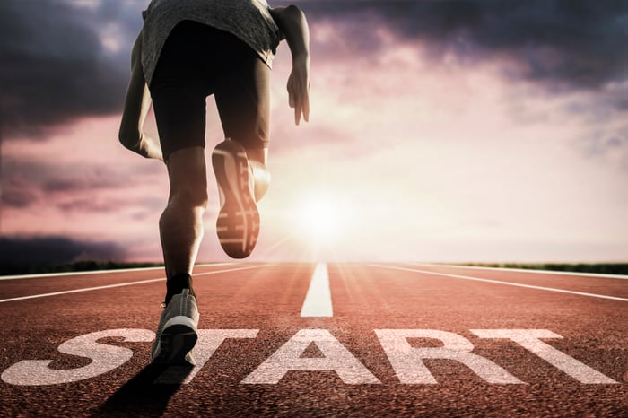 A person running from the start line on a track.