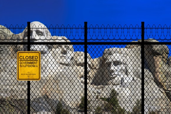 Mount Rushmore with a fence and a "closed" sign in the foreground