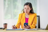 Analyst_studying_chart_while_holding_smartphone_in_hand