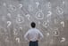 Man looking at drawing of money bags and question marks