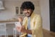 excited man celebrates while looking at smartphone.