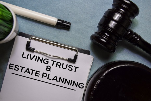Clipboard labeled “Living Trust & Estate Planning” beside a judge’s gavel.