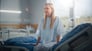 Patient sitting on hospital bed.