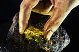 Hand holding a nugget of gold