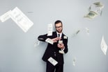 Person in business attire smirking and scattering $100 bills