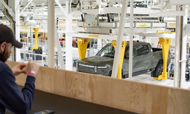 truck on assembly line while employee looks at it from a distance_rivian_