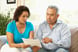 Senior couple pointing at document