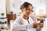 Person looking pleased while gazing at a smartphone