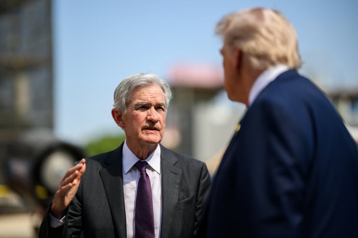Jerome Powell talking with Donald Trump in front of the Federal Reserve building.