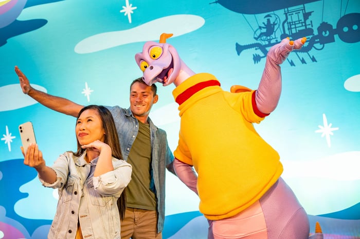 Park guests staging a selfie photo with Figment at Disney World's Epcot.