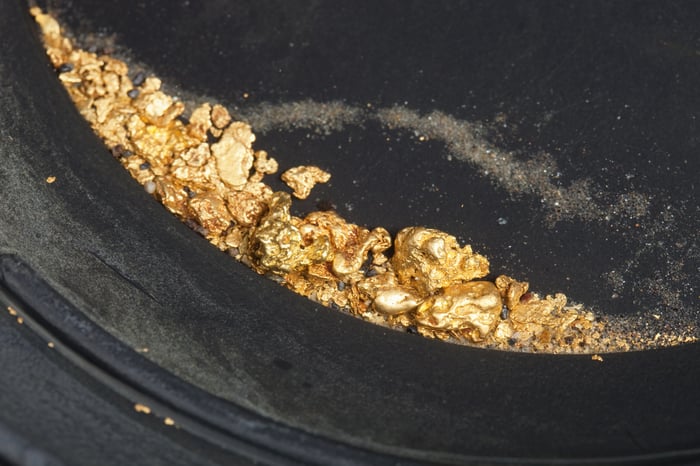 A prospectors pan filled with gold nuggets.