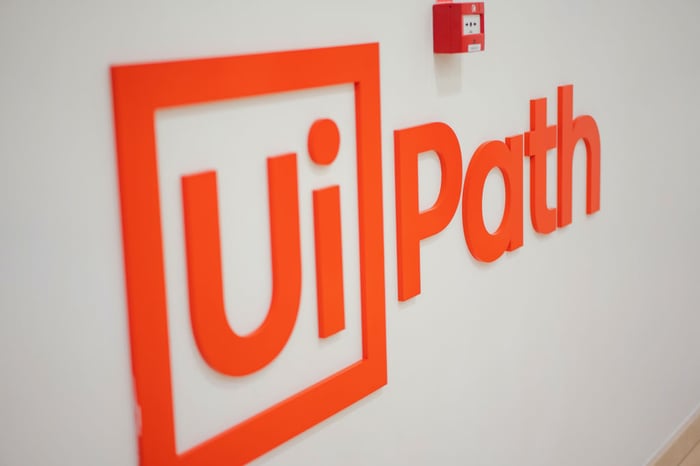 An orange UiPath logo on a white wall.