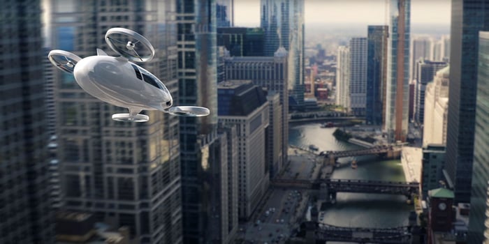 Electric vertical takeoff and landing (eVTOL) aircraft flying through a city.