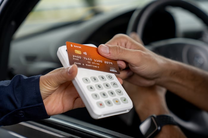 Someone paying with a credit card from their car.