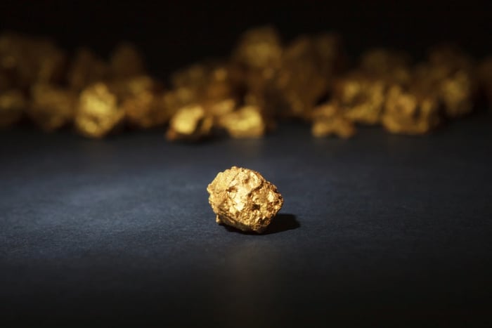 Some gold ingots gleam against a black background.
