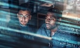 Two people looking at data on a screen