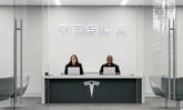 tesla service center with two associates at desk with tesla logo