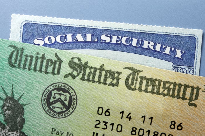 Top of a Social Security card peeking out from behind a U.S. Treasury check.