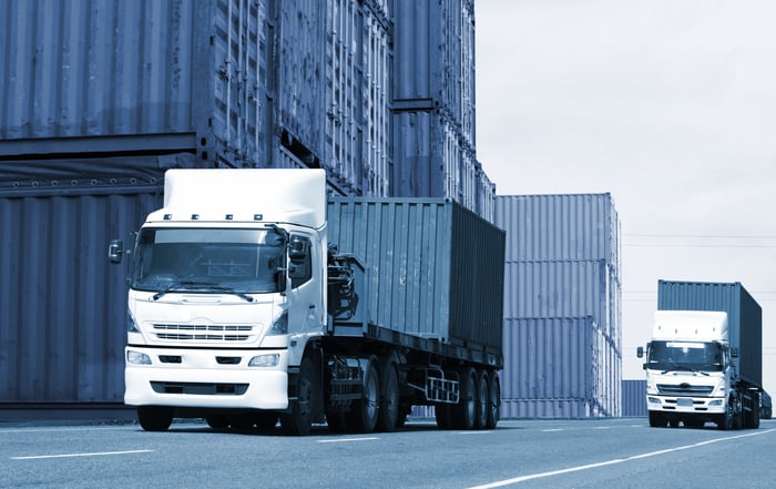 Trucks taking containers from a shipping dock.