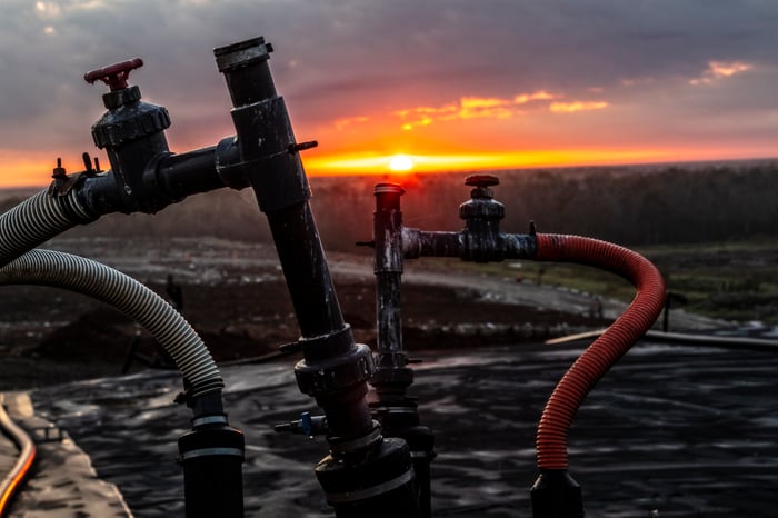 Methane pipes at a landfill with the sun setting in the background.