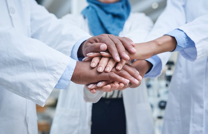 Medical professionals joining hands. 