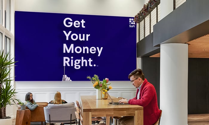 A SoFi slogan poster urging people to get your money right is on the wall in an office.