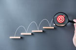 24_12_02 A bullseye jumping up stairs with a magnifying glass on it _MF Dload GettyImages-1511226415-1200x798-36b7a2e