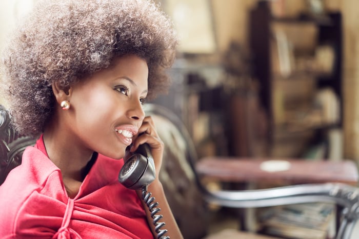 A person talking on a landline.