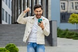 Young smartphone user celebrating