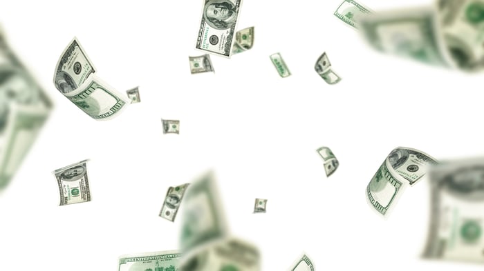Cash falling against a white background. 
