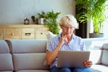 Senior woman holding laptop GettyImages-1278976690